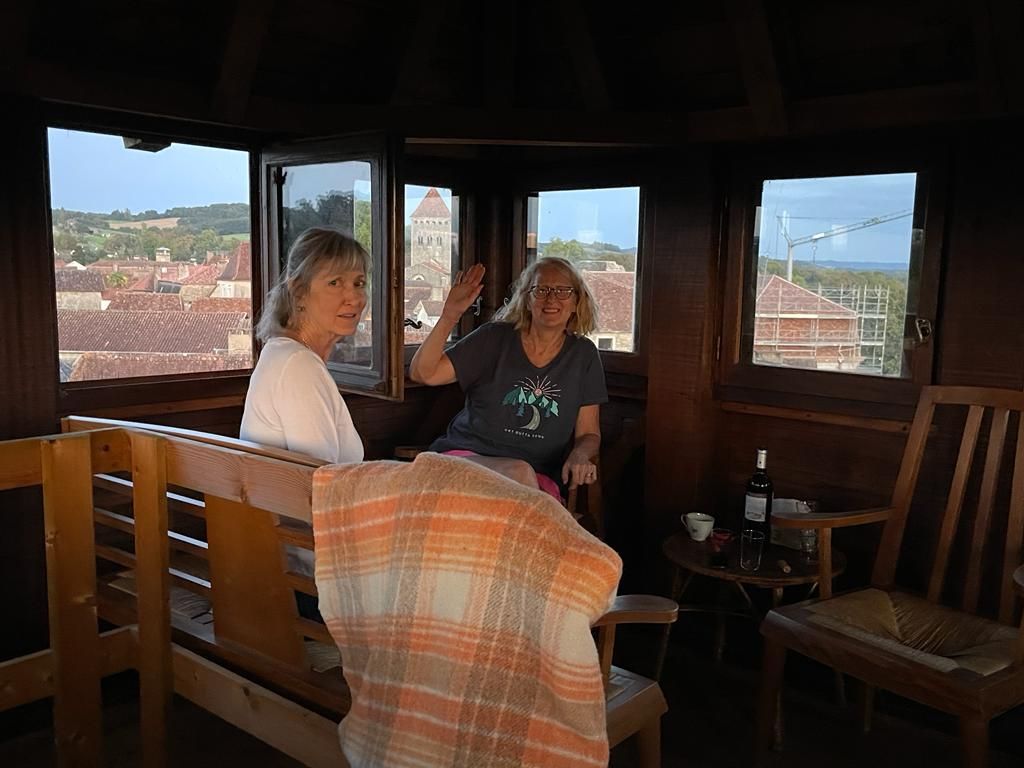 Two artists relaxing in the wooden tower lookout above the village rooftops