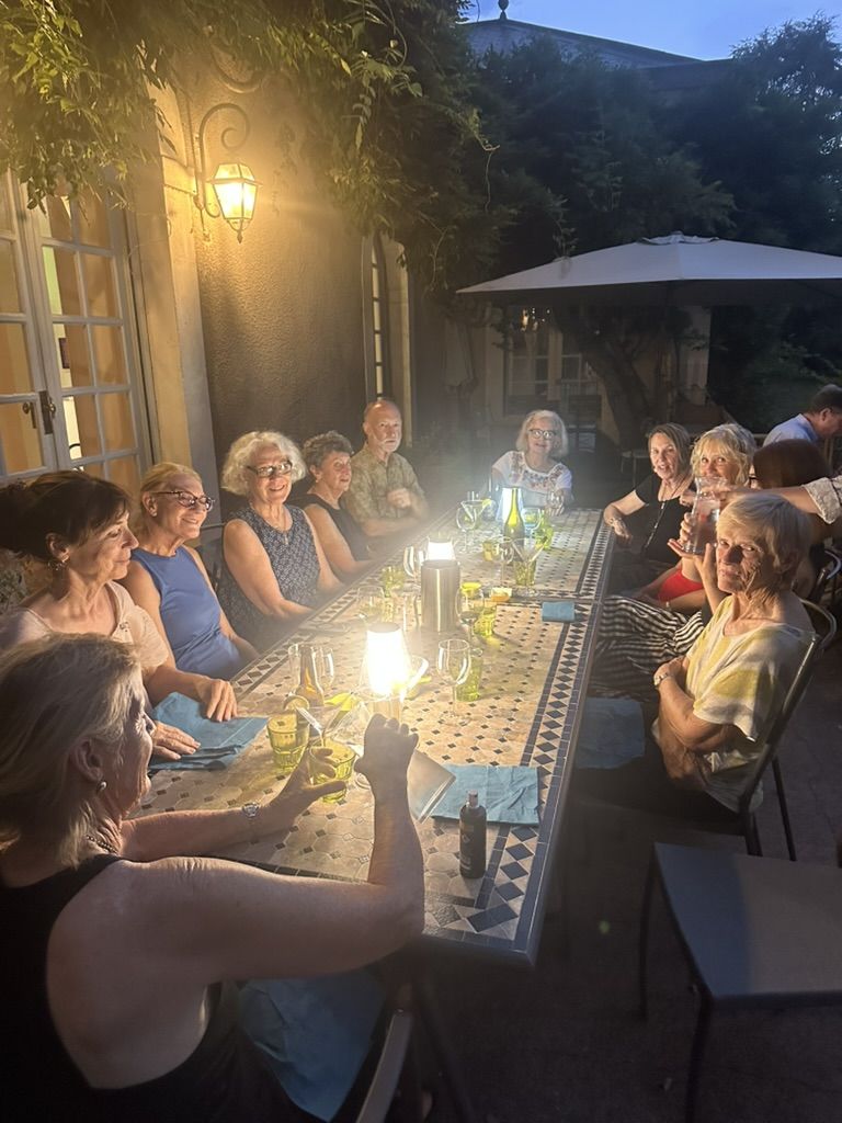 A long table of artists dining by lamplight at the local arts café